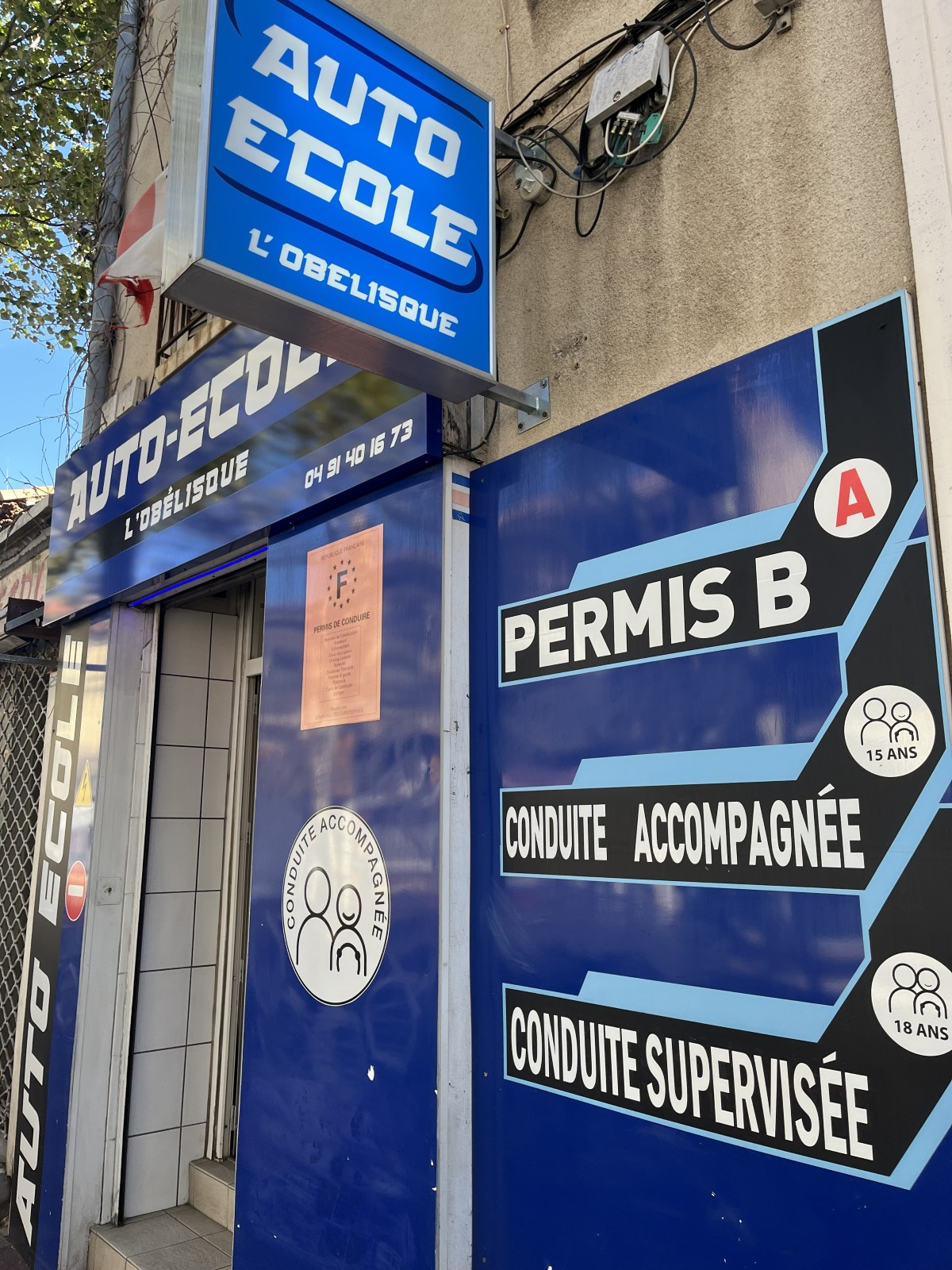 Façade de l'Auto-école de l'Obélisque avec le panneau des formations au permis B